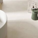 Do łazienki najlepiej stosować płytki podłogowe matowe lub z lekką strukturą, oznaczone parametrem antypoślizgowym R10 lub wyższym. Taka powierzchnia poprawia bezpieczeństwo antypoślizgowe w kontakcie bosej stopy z wodą i zmniejsza ryzyko wypadku na mokrej podłodze. Fot. Domni.pl